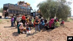 Des Syriens fuyant les combats entre les troupes turques et les milices syriennes kurdes se reposent entre Afrin et Azaz en Syrie, le 14 mars 2018.