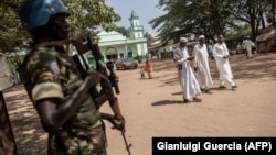 Un membre de la Minusca monte la garde alors que des musulmans quittent la Grande Mosquée dans le quartier PK5 de Bangui, le 27 novembre 2015.