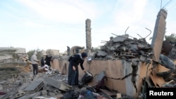 Palestinians inspect the site of an Israeli strike on a house, amid the ongoing conflict between Israel and Hamas, in Deir Al-Balah in the central Gaza Strip, Jan. 15, 2025.