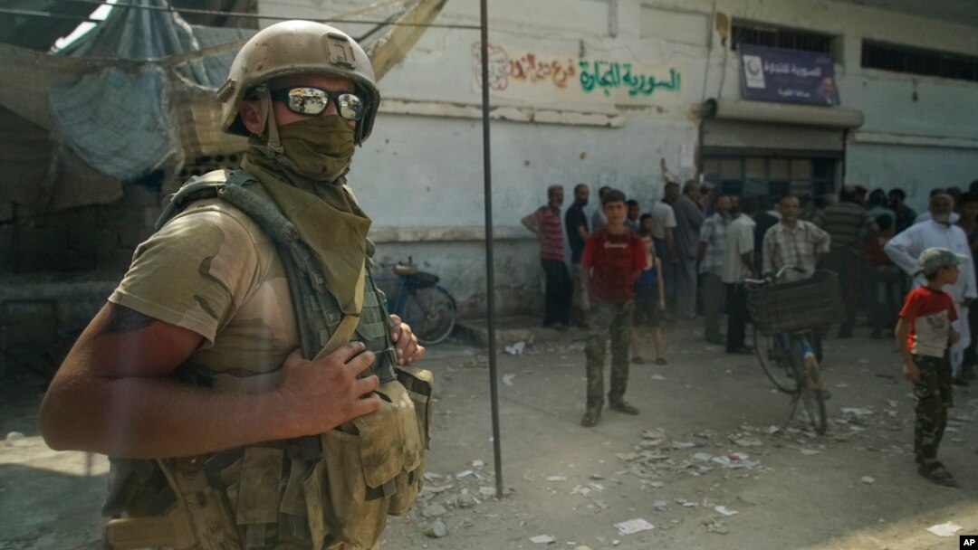 A Russian soldier guards the area at a city market in Deir el-Zour, Syria, Sept. 15, 2017. A U.S.-backed force in Syria said a Russian airstrike wounded six of its fighters Saturday near Deir el-Zour city. 