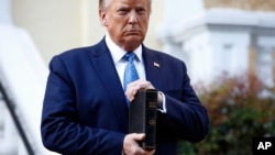 (ARCHIVO) El entonces presidente Donald Trump sostiene una Biblia mientras visita las afueras de la Iglesia de San Juan, frente al Parque Lafayette, desde la Casa Blanca, el 1 de junio de 2020, en Washington.