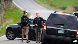 Sejumlah anggota kepolisian tampak membawa senjata ketika berjaga di sebuah area di Bowdoin, Maine, pada 26 Oktober 2023. (Foto: AP/Steven Senne)