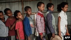 FILE - Children, who fled the violence in Ethiopia's Tigray region, wait in line for breakfast organized by a self-volunteer, in Mekelle, the capital of Tigray region, June 23, 2021. 