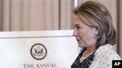 Secretary of State Hillary Rodham Clinton walks past a portrait of the late Ambassador Richard Holbrooke, Friday, Jan. 14, 2011, at the State Department in Washington.