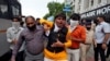 အိန္ဒိယနိုင်ငံ Ahmedabad မြို့မှာ တရုတ်ထုတ်ကုန်တွေကို သပိတ်မှောက်ဖို့ ဆန္ဒပြသူတဦးကို ထိန်းသိမ်းခေါ်ဆောင်လာတဲ့ အရပ်ဝတ် အိန္ဒိယရဲတပ်ဖွဲ့ဝင်များ။ (ဇူလိုင် ၆၊ ၂၀၂၀)