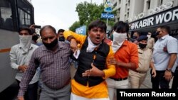 အိန္ဒိယနိုင်ငံ Ahmedabad မြို့မှာ တရုတ်ထုတ်ကုန်တွေကို သပိတ်မှောက်ဖို့ ဆန္ဒပြသူတဦးကို ထိန်းသိမ်းခေါ်ဆောင်လာတဲ့ အရပ်ဝတ် အိန္ဒိယရဲတပ်ဖွဲ့ဝင်များ။ (ဇူလိုင် ၆၊ ၂၀၂၀)