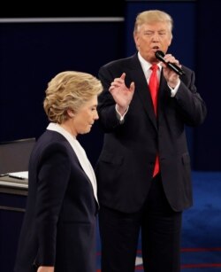 FILE - In this Oct. 9, 2016 file photo, Democratic presidential nominee Hillary Clinton walks past Republican presidential nominee Donald Trump during the second presidential debate at Washington University in St. Louis.