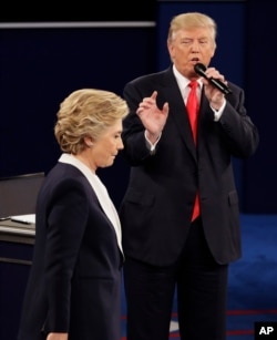 FILE - In this Oct. 9, 2016 file photo, Democratic presidential nominee Hillary Clinton walks past Republican presidential nominee Donald Trump during the second presidential debate at Washington University in St. Louis.