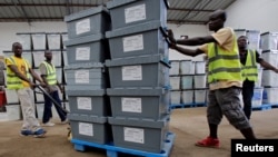 Election workers move boxes of voting materials at the National Electoral Commission headquarters in Monrovia, Oct. 9, 2017.