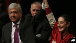 FILE - Presidential hopeful Andres Manuel Lopez Obrador, left, and Claudia Sheinbaum, coordinator of the Morena political party, hold hands at an event at the National Auditorium in Mexico City, Nov. 20, 2017.