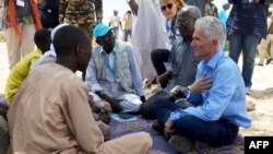 Le secrétaire général adjoint aux affaires humanitaires des Nations Unies (OCHA) et le Coordonnateur des secours d'urgence Mark Lowcock, à gauche, discute avec des hommes dans un camp des Nations Unies pour les réfugiés et les personnes déplacées à NGag