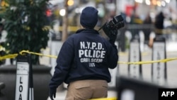 A Crime Scene Unit officer photographs the scene where CEO of UnitedHealthcare Brian Thompson, 50, was shot as he entered the New York Hilton early on December 4, 2024 in New York.