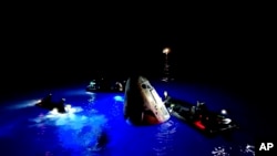 This image made from SpaceX video shows its capsule, center, carrying tech entrepreneur Jared Isaacman with his crew after it reached the Gulf of Mexico near Florida's Dry Tortugas, Sept. 15, 2024.