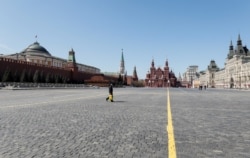 People walk across an empty Red Square in central Moscow, Russia, May 1, 2020.