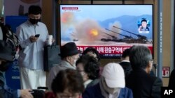 Una pantalla de TV en una estación ferroviaria en Seúl, Corea del Sur, muestra una imagen de archivo de maniobras militares norcoreanas durante un programa noticioso, el viernes 14 de octubre de 2022.