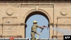 A firefighter sprays disinfectant in front of the India Gate during a nationwide lockdown as a preventive measure against COVID-19 in New Delhi on April 17, 2020.