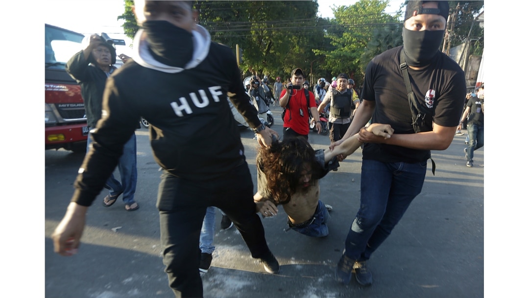 FILE - Plain-clothed police officers arrest a student protester during a rally in Makassar, South Sulawesi province, Indonesia, Sept. 26, 2019.