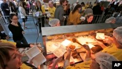 Volunteers hand out free meals made from rescued ingredients organized by the charity organization Oz Harvest in Sydney's central business district, July 29, 2013. The organizers goal is to feed 5,000 people over a lunch period in a bid to raise awareness to the amount of food wasted each day.