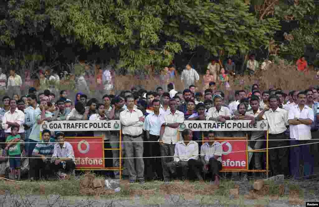 Onlookers watch the rescue operation at the site of a collapsed building that was under construction in Canacona, India, Jan. 5, 2014. 