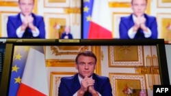 French President Emmanuel Macron is seen on monitors in a control room at AFP headquarters as he addresses the nation during a televised broadcast from the presidential Elysee Palace, on the day of the prime minister's resignation on Dec. 5, 2024.