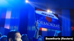 Seorang pendukung Partai Demokrat memegang plakat saat acara kampanye pemilihan presiden di Jakarta 3 April 2014. (Foto: REUTERS/Beawiharta)