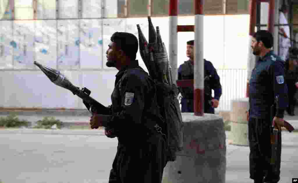 Afghan security personnel stand guard at the site of a deadly attack in Kabul. Officials say the political offices of the president&#39;s running mate Amrullah Saleh were hit by a large explosion and stormed by an unknown number of attackers.