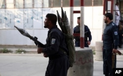 FILE - Afghan security personnel stand guard after the offices of Amrullah Saleh was targeted in a deadly attack, in Kabul, Afghanistan, July 28, 2019.
