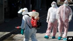 Arhiva - Zdravstveni radnici dezinfikuju prilaz ambulantama Klinike za infektivne i tropske bolesti u Beogradu, 16. marta 2020. (AP Photo/Darko Vojinovic)