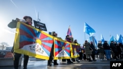 Aktivis Tibet dan Uyghur menggelar protes di luar kantor PBB di Jenewa, Swiss, pada 23 Januari 2024, saat peninjauan catatan HAM China berlangsung di dalam kantor tersebut. (Foto: AFP/Fabrice Coffrini)