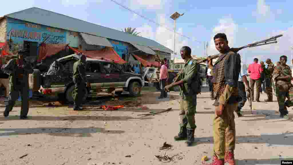 Des policiers somaliens se rassemblent près de la voiture détruite dans l&#39;attaque-suicide dans la capitale somalienne Mogadiscio, le 9 mars 2016.