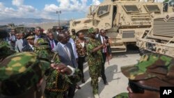 Kenya's President William Ruto, center-left, visits Kenyan police, part of a U.N.-backed multinational force deployed in Haiti to help curb gang violence in the country, at their base in Port-au-Prince, Haiti, Sept. 21, 2024. 