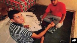 In this undated photo, published Tuesday Aug. 6, 2018 by the Spanish newspaper La Vanguardia, terrorists identified as Younes Abouyaaqoub, left and Youssef Aalla, prepare explosives at a house in Alcanar, Spain. 