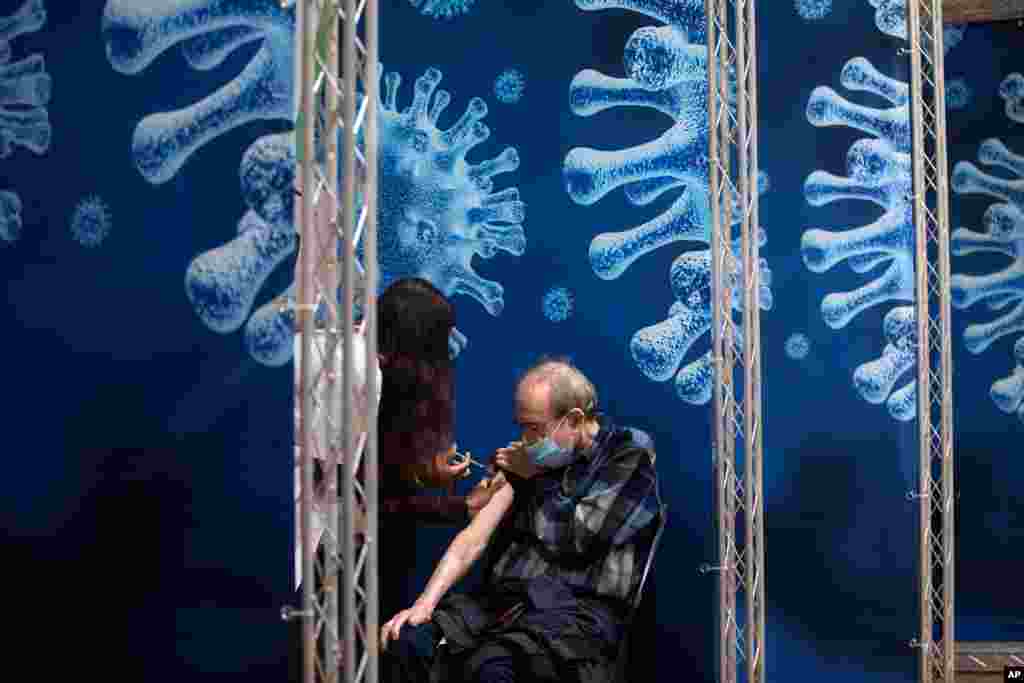 A man receives a coronavirus vaccine from medical staff at a COVID-19 vaccination center in Ramat Gan, Israel.