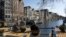 FILE - Men enjoy the afternoon sun at the Brouwersgracht canal in Amsterdam, April 2, 2013. 