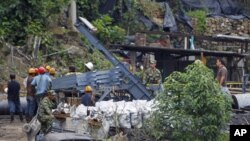 Rescue workers stand in front of the coal mine La Preciosa after an explosion at the mine in Sardinata, Norte de Santander province, January 27, 2011