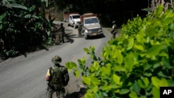 Miembros de un grupo rebelde que se separó de las antiguas Fuerzas Armadas Revolucionarias de Colombia (FARC) operan un puesto de control en la región del Cañón de Micay, en el suroeste de Colombia, el miércoles 14 de agosto de 2024. 