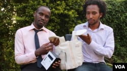 Makerere University Telecom graduates Brian Turyabagye (left) and Besufekad Shifferaw (Right) show off the smart jacket that will be used in the diagnosis of pneumonia in children, Kampala, Uganda, April 5, 2017. (H. Althumani/VOA)