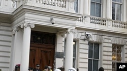 British police stand guard outside the Iranian Embassy in London. Britain's foreign secretary on Wednesday ordered all Iranian diplomats out of the U.K within 48 hours following attacks on the British embassy and a residential compound in Tehran, November
