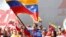 This Venezuelan government photo shows President Nicolas Maduro waving a flag to celebrate the anniversary the "Caracazo" revolutionary uprising; in a speech at the rally, he announced the arrest of a U.S. pilot for alleged spying, Feb. 28, 2015.