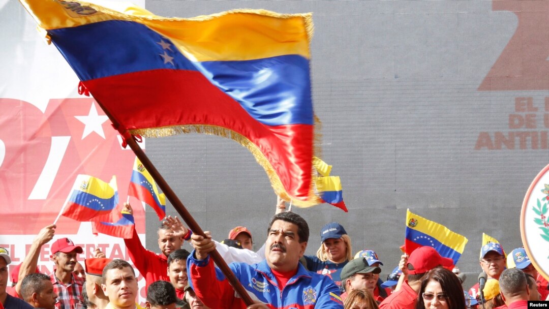 Presiden Nicolas Maduro melambaikan bendera merayakan peringatan kebangkitan revolusi "Caracazo"; dalam pidatonya ia mengumumkan penangkapan pilot AS yang diduga melakukan spionase, 28 Februari 2015.