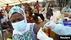 FILE - A woman receives a vaccine to protect against Ebola during a vaccination drive in the Alakro neighborhood of in Abidjan, Ivory Coast, Aug. 17, 2021. 