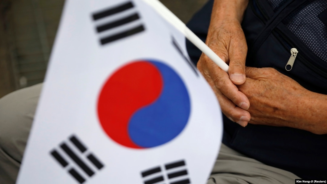 Seorang veteran perang Korea Selatan memegang bendera nasional dalam upacara memperingati 70 tahun Perang Korea, di dekat zona demiliterisasi yang memisahkan kedua Korea, di Cheorwon, Korea Selatan, 25 Juni 2020. (Foto: REUTERS/Kim Hong-Ji )