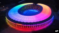 FILE - The illuminated Olympic Stadium is pictured in Berlin on June 23, 2021. Scars of World War II and relics from its Nazi past are preserved at Berlin's Olympiastadion.