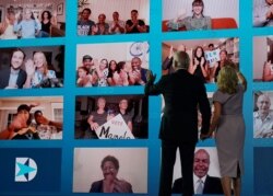 FILE - Joe Biden and his wife wave to supporters watching remotely during the last day of the Democratic National Convention, being held virtually, in Wilmington, Delaware, Aug. 20, 2020.