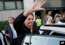 Mantan Presiden Brasil Jair Bolsonaro melambaikan tangan kepada pendukungnya di luar Bandara Santos Dumont setibanya di Rio de Janeiro, Brazil, Kamis, 29 Juni 2023. (Foto: AP)