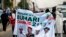 All Progressives Congress (APC) supporters hold a banner with a photograph of former military ruler Muhammadu Buhari in Lagos, Nigeria, Dec. 10, 2014.