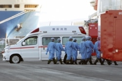 Members of Japan Self Defense Forces walk into the quarantined cruise ship Diamond Princess in the Yokohama Port, Feb. 9, 2020, in Yokohama, Japan.