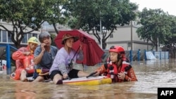 Rescue personnel evacuate residents from a flooded area following heavy rains caused by Typhoon Haikui in Xiamen, in China's southern Fujian province on Sept. 6, 2023. 