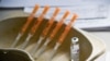 FILE - A vial and syringes with the AstraZeneca COVID-19 vaccine are seen at a makeshift inoculation site in Luton, England, March 21, 2021. The British government says it will begin rolling out COVID-19 booster shots in early September.