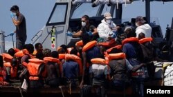 Kapal penyelamat "Astral" milik LSM Spanyol, Open Arms, membantu para migran di perairan internasional di perairan sebelah selatan Lampedusa, di Laut Tengah, Minggu, 11 Agustus 2024. (Foto: Juan Medina/Reuters)